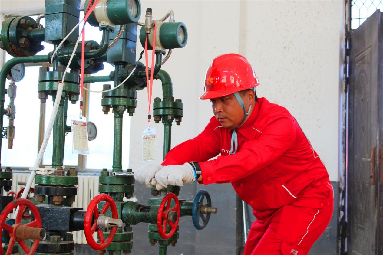 靖边采油厂杨米涧采油队技术员段玉鹏保养注水设备,保障安全平稳运行。李振华摄