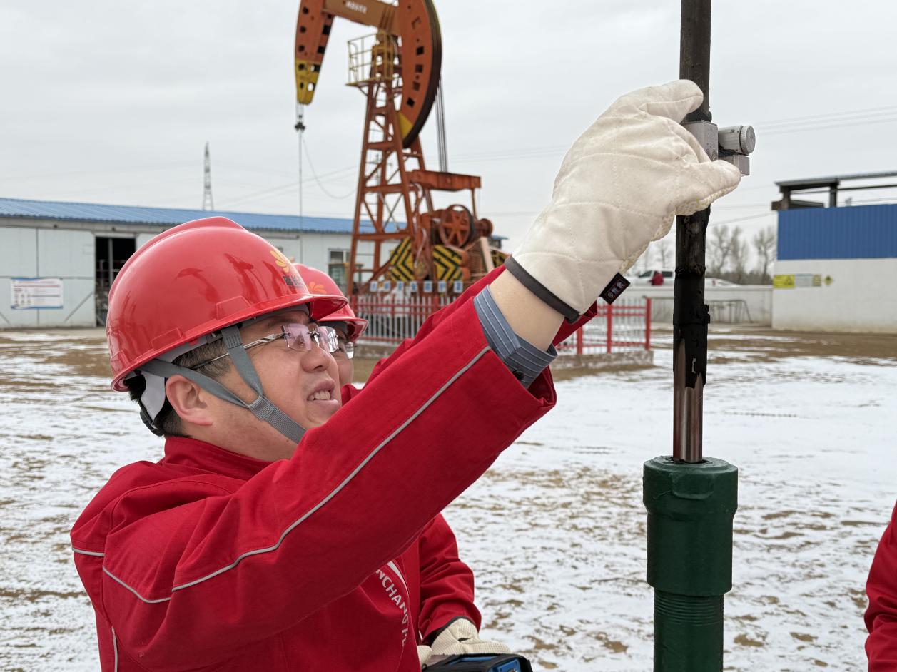 2月10日在延长油田股份有限公司定边采油厂东仁沟采油队1827井场杨浩和技术组的工友们穿梭在抽油机间逐井巡检。李德龙（摄） (3)